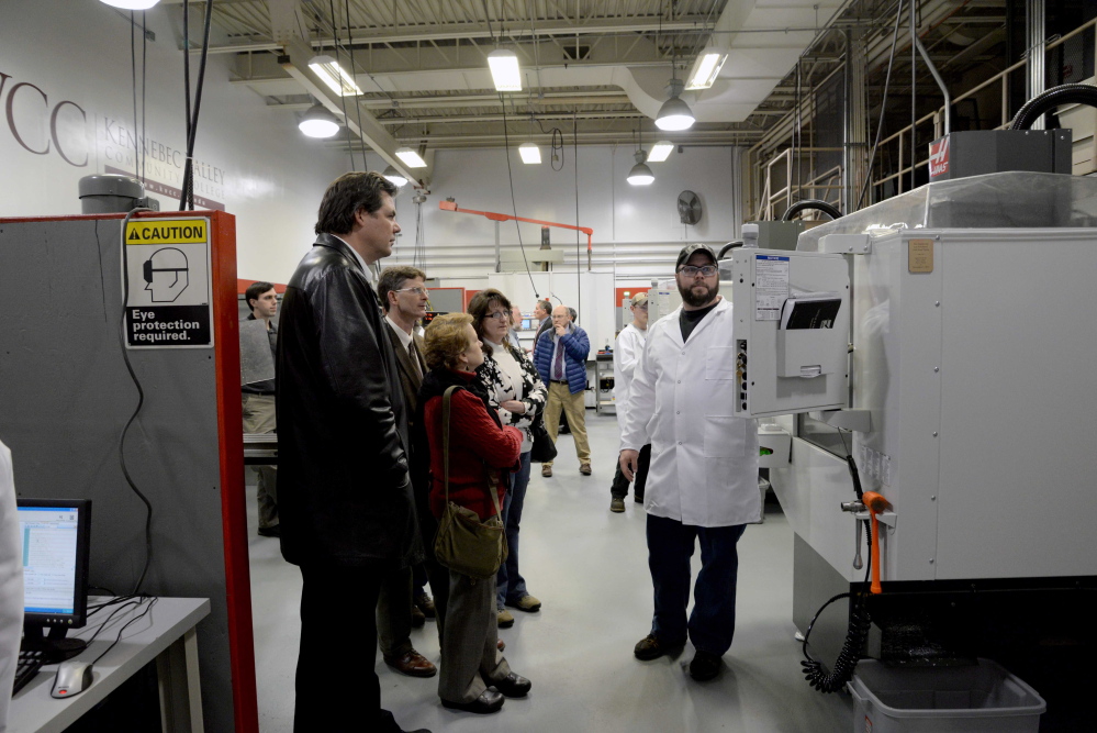 Kennebec Valley Community College precision machining technology student Cameron Michaud, right, explains the capabilities of one of the new milling machines in the college’s updated laboratory at an open house event recently.