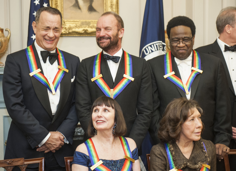2014 Kennedy Center Honorees Tom Hanks, and Sting share a laugh as they gather with Patricia McBride, front left,  Lily Tomlin, front right, and Al Green, right, following the State Department Dinner for the Kennedy Center Honors on Saturday in Washington.