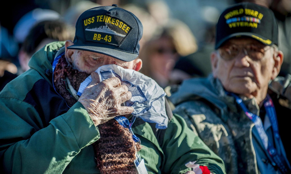 U.S. Navy veteran Robert MacLennan, 92, of Sanford, Va, wipes a tear after being presented with a flower during a Pearl Harbor remembrance service in Washington. “In a way, I feel honored,” he said, “but in another way, it gives you nightmares.”