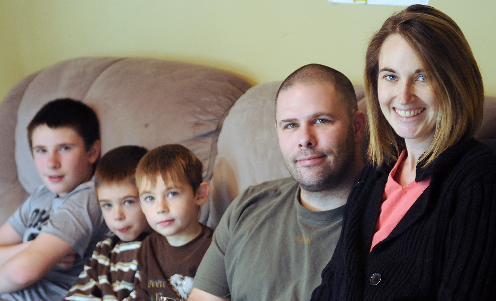 Cyndi MacMaster sits with her husband, Scott, and their sons, Tripp, 5, center, Parker, 7, and Jake, 12, on Sunday at their Dresden home. People are rallying behind Cyndi after a devastating recurrence of cancer, including donating funds so she can seek alternative treatments.