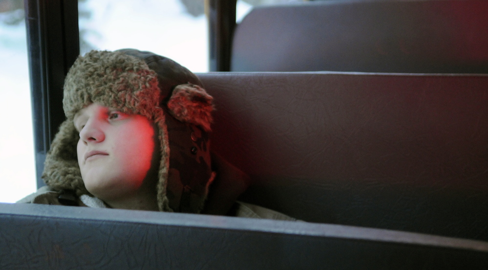 Richard Giffin, 22, watches from a school bus that sheltered residents as a multi-unit apartment building burned Tuesday morning. The early morning blaze on State Street in Augusta displaced five families, according to Augusta Fire Chief Roger Audette.