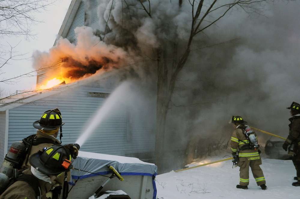 Firefighters work Tuesday at extinguishing a blaze on State Street in Augusta.