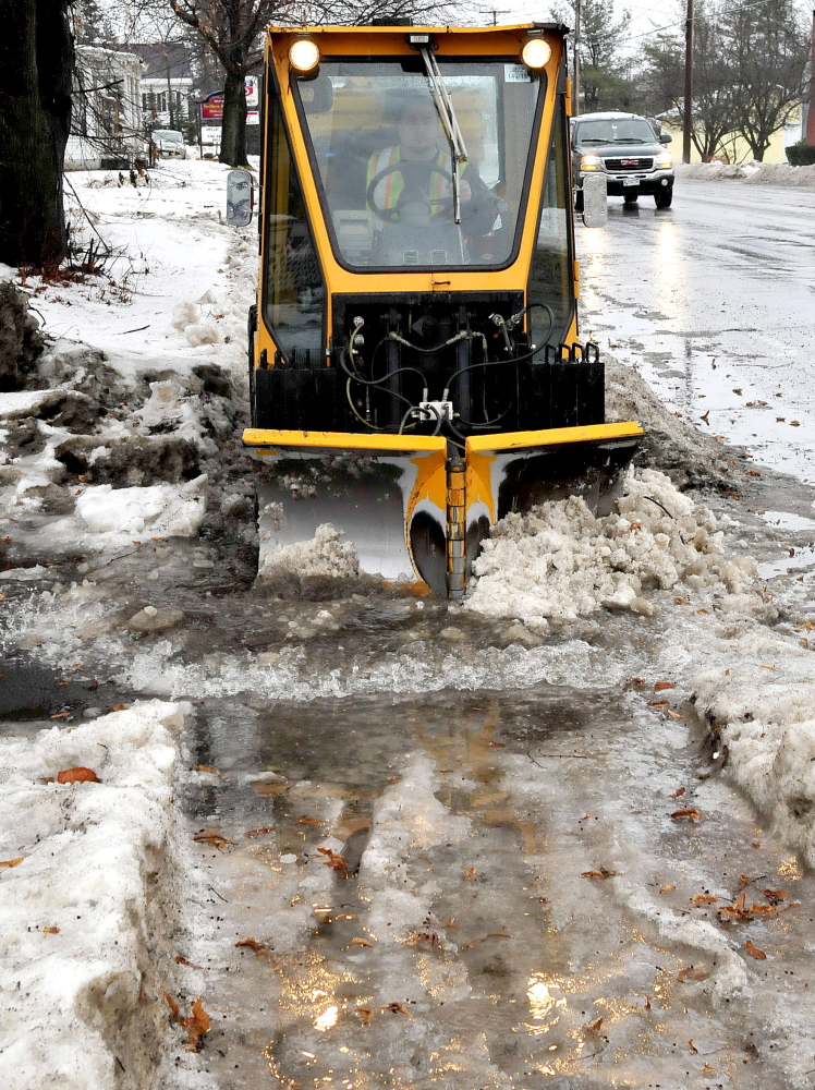 Aaron Poulin of the Fairfield Public Works Department plows snow, ice and water on sidewalks in Fairfield on Wednesday.