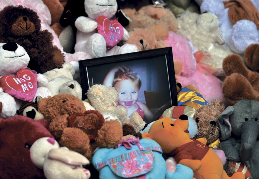 A picture of Ayla Reynolds is surrounded by teddy bears on the steps of the Waterville City Hall during a vigil for the missing toddler in January 2012.