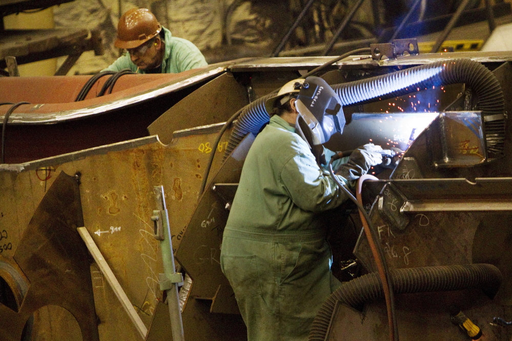 Shipbuilders work on the assembly of ship interior components at Bath Iron Works in Bath on Wednesday