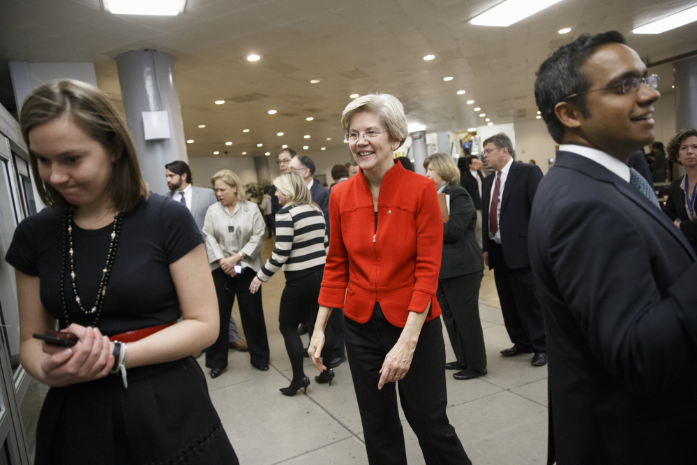 Sen. Elizabeth Warren, D-Mass., a member of the Senate Banking Committee, joins other lawmakers in the rush to the Senate floor on Capitol Hill in Washington, Thursday, for a procedural vote to advance the $585 billion defense bill.