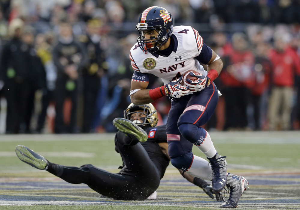 Navy wide receiver Jamir Tillman, 4, rushes past Army defensive back Josh Jenkins for a first down in the first half of the Army-Navy game Saturday in Baltimore. Navy won 17-10, its 13th victory in a row over Army.