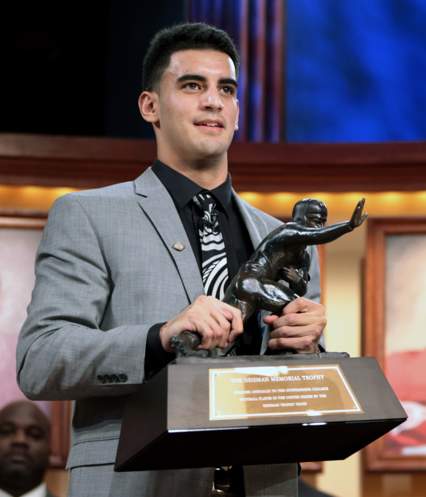 Oregon quarterback Marcus Mariota holds the Heisman Trophy after being named college football’s best player during the Heisman Trophy presentation in New York on Saturday.
