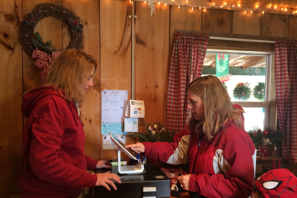 Kimberly Solberg, right, of Madison, pays employee Melissa Fredsall for a Christmas tree at Trees to Please on Sunday. The tree farm has lost about five percent of their profit this year from people stealing trees and wreaths, said owner Todd Murphy.