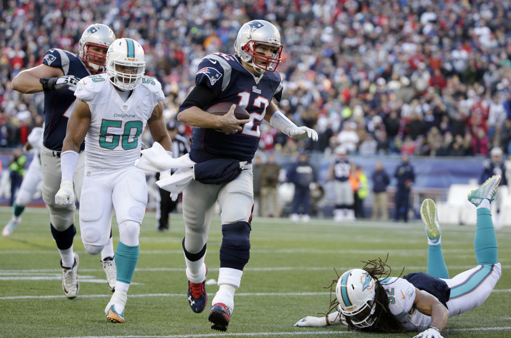 New England Patriots quarterback Tom Brady (12) runs with the ball as Miami Dolphins defensive end Olivier Vernon (50) gives chase in the second half Sunday in Foxborough, Mass.