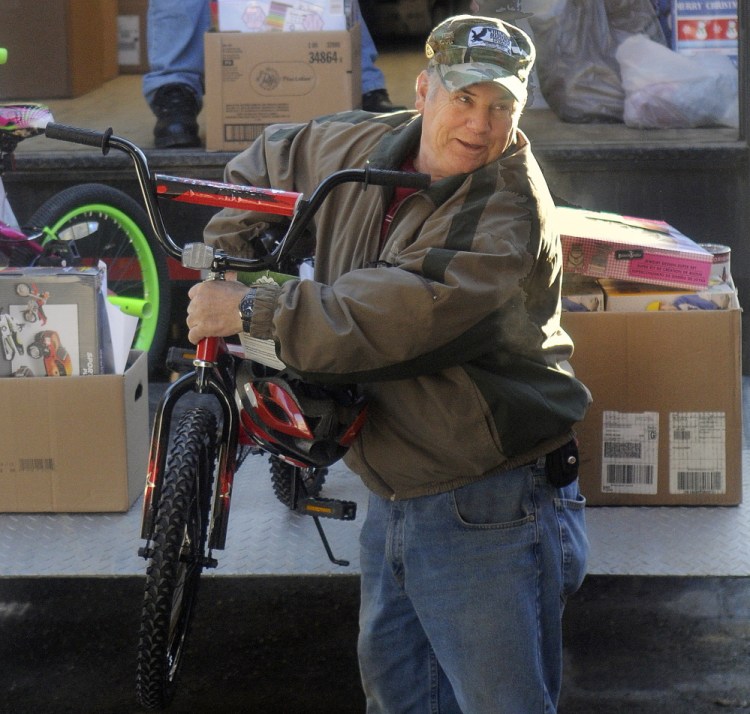 Togus employee Mahlon Lincoln unloads a bike donated by the federal hospital’s employees at the Salvation Army in Augusta on Monday. The ride will be given to a child in the area during the holidays.