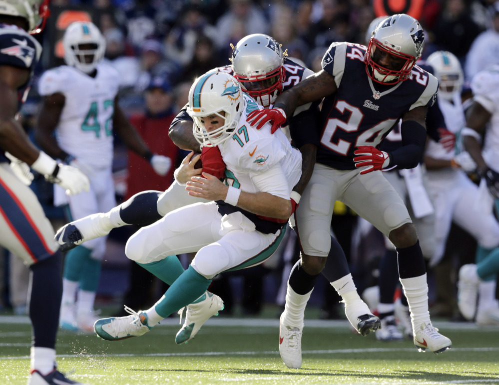 New England Patriots outside linebacker Dont’a Hightower, rear, tackles Miami Dolphins quarterback Ryan Tannehill (17) alongside Patriots cornerback Darrelle Revis (24) in the first half Sunday in Foxborough, Mass. The Patriots won 41-13 to clinch the AFC East title.