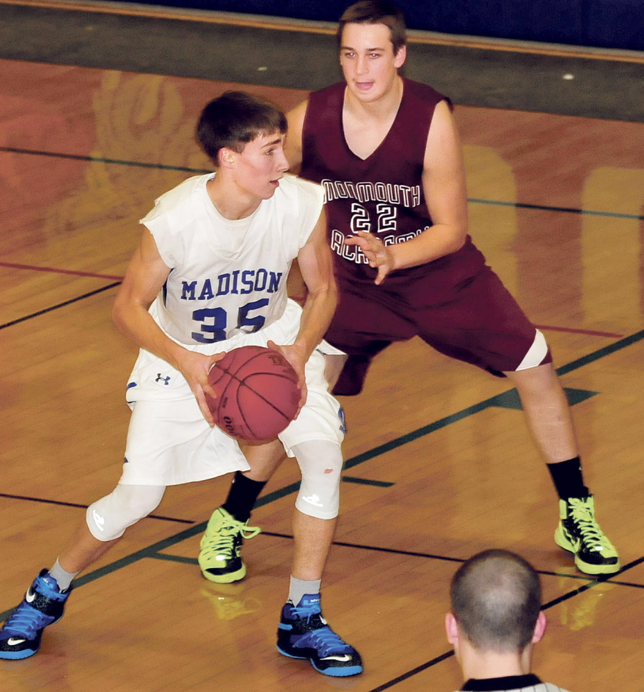 Madison’s Chase Malloy looks for a teammate as he is defended by Monmouth’s Avery Amero on Monday in Madison.