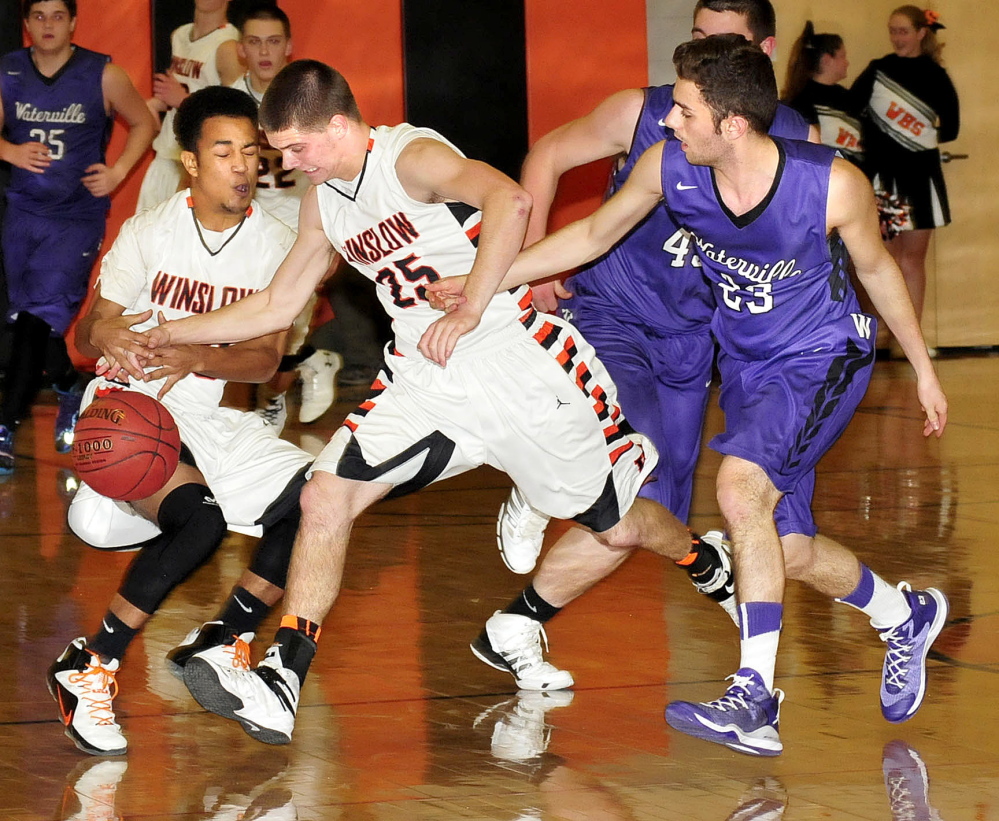 Staff photo by David Leaming 
 Winslow's Earle Keanu, left, and Trenton Bouchard chase a loose ball as Waterville's Nicholas Elias, left, pressures during a KVAC B game Tuesday.