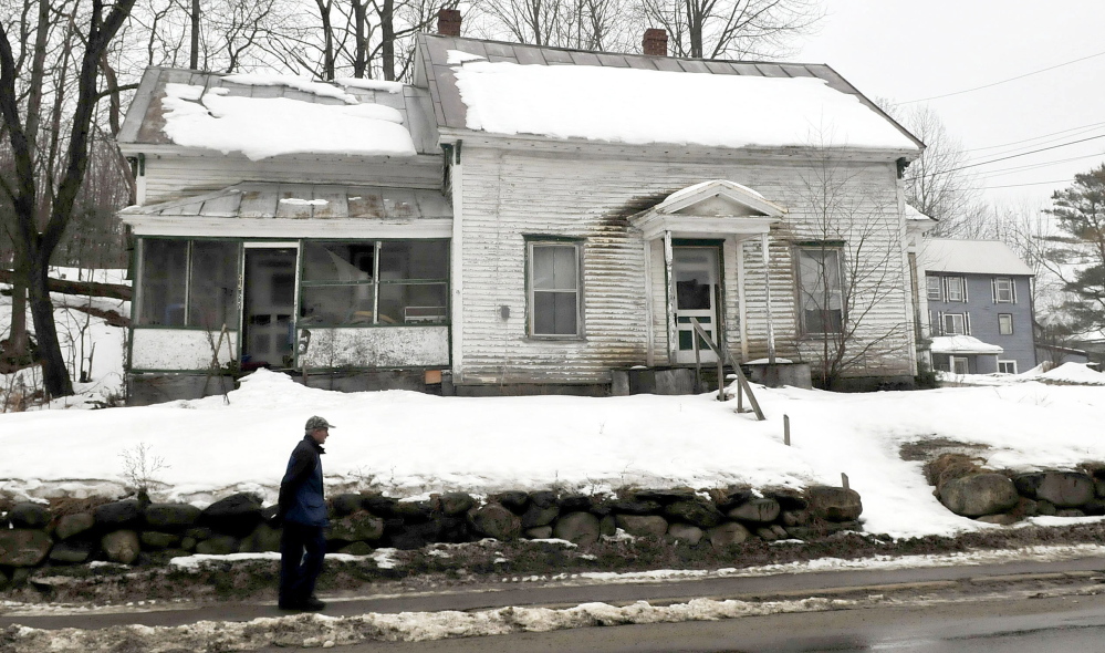 A pedestrian walks past an empty home near downtown Wilton on Tuesday. Portions of the town may benefit from federal grant money for upgrades if a percentage of the property is designated as slum and blight.