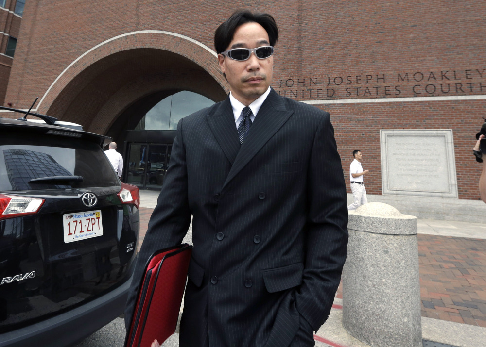 In this Sept. 11, 2014 file photo, Glenn Adam Chin, former supervisory pharmacist at the New England Compounding Center, departs federal court in Boston. Chin was among 14 people from the pharmaceutical  company arrested at their homes Wednesday, Dec. 17, 2014. Tainted steroids manufactured by the pharmacy were blamed  for a fungal meningitis outbreak that killed 64 people across the country.