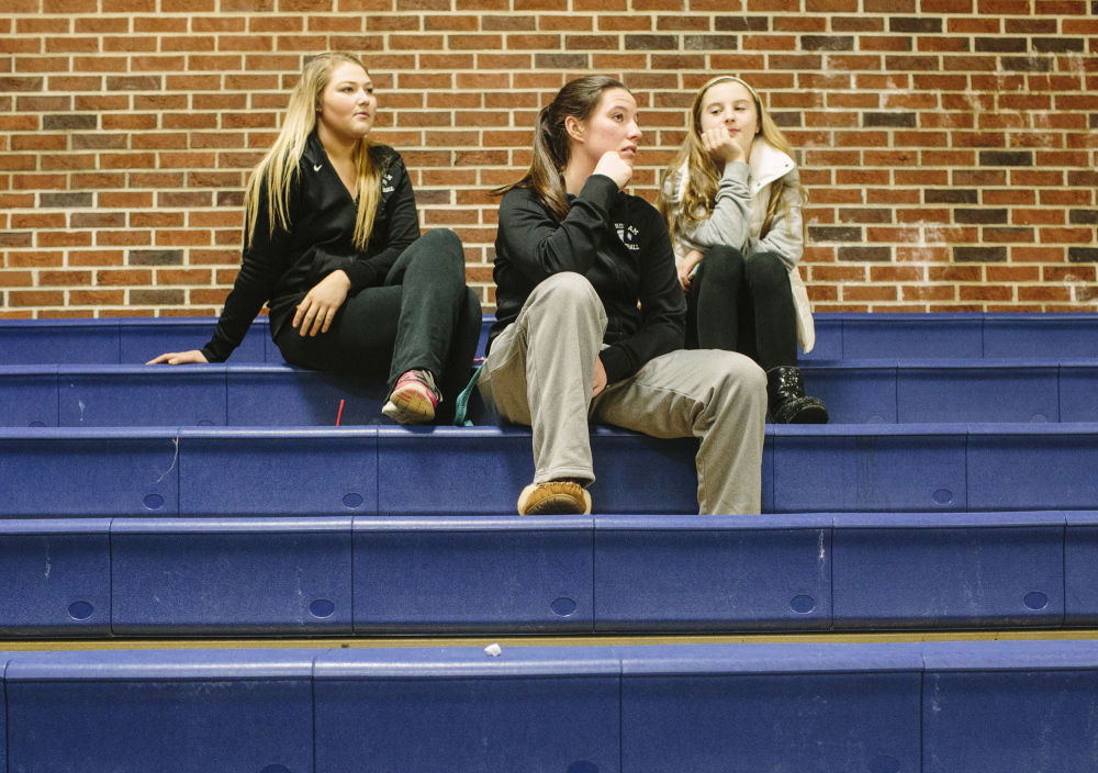 Windham varsity basketball players Julia Linevitch, left, Sadie Nelson, center, and Mya Mannette watch the boys’ game Wednesday, which was moved to USM in Gorham. They said when their school was evacuated Monday they thought it was just another lockdown drill.