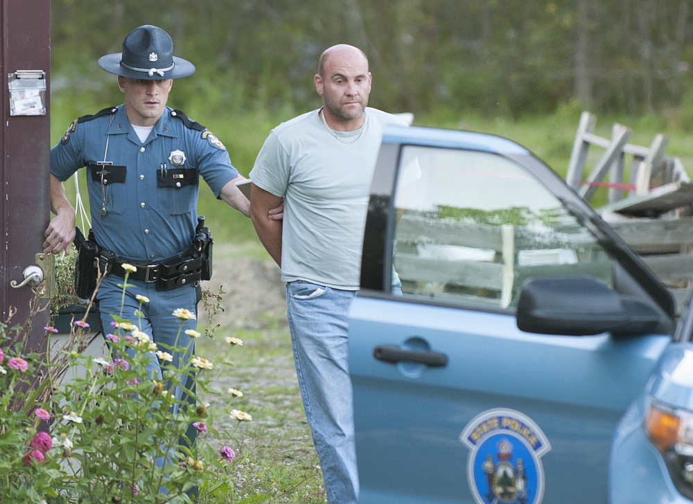 Maine State Police Trooper Scott Duff leads Marc Alberi, of Newport, to his cruiser in handcuffs Sept. 8 after serving him with a search warrant.