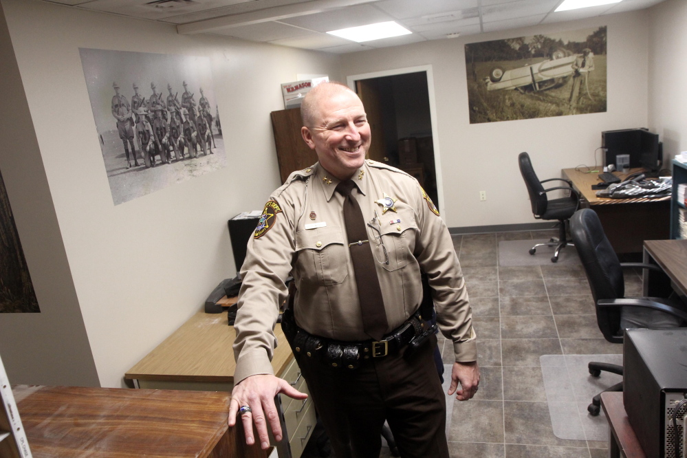 Franklin County Sheriff Scott Nichols talks about the renovations to the department in Farmington on Friday. Nichols is standing in the patrol room, which used to be divided into two rooms. The photographs on the walls are pictures of the Franklin County department from over the years.