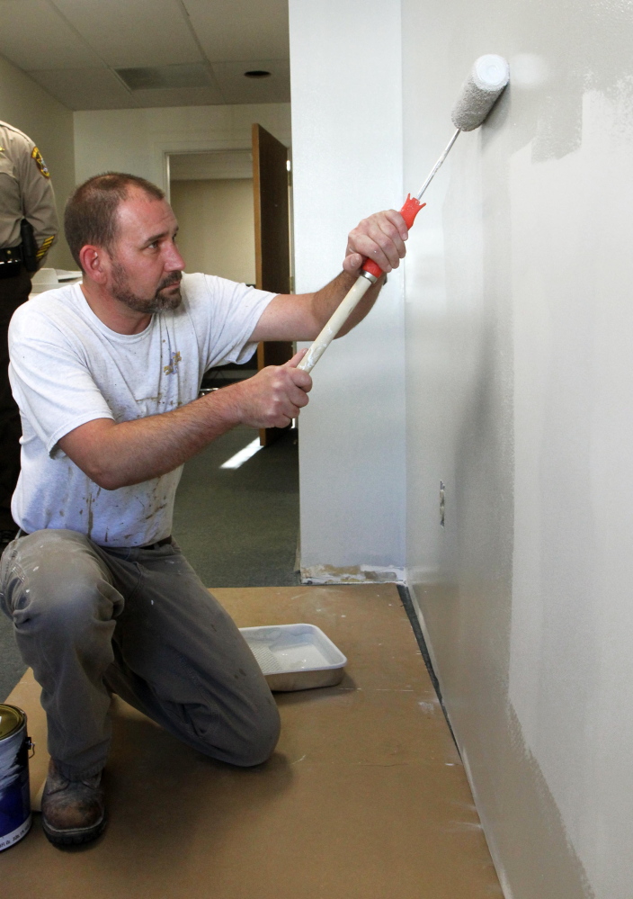 Brian Hartley of Anson finishes up painting the last room to be revovated at the Franklin County sheriff’s office in Farmington on Friday.