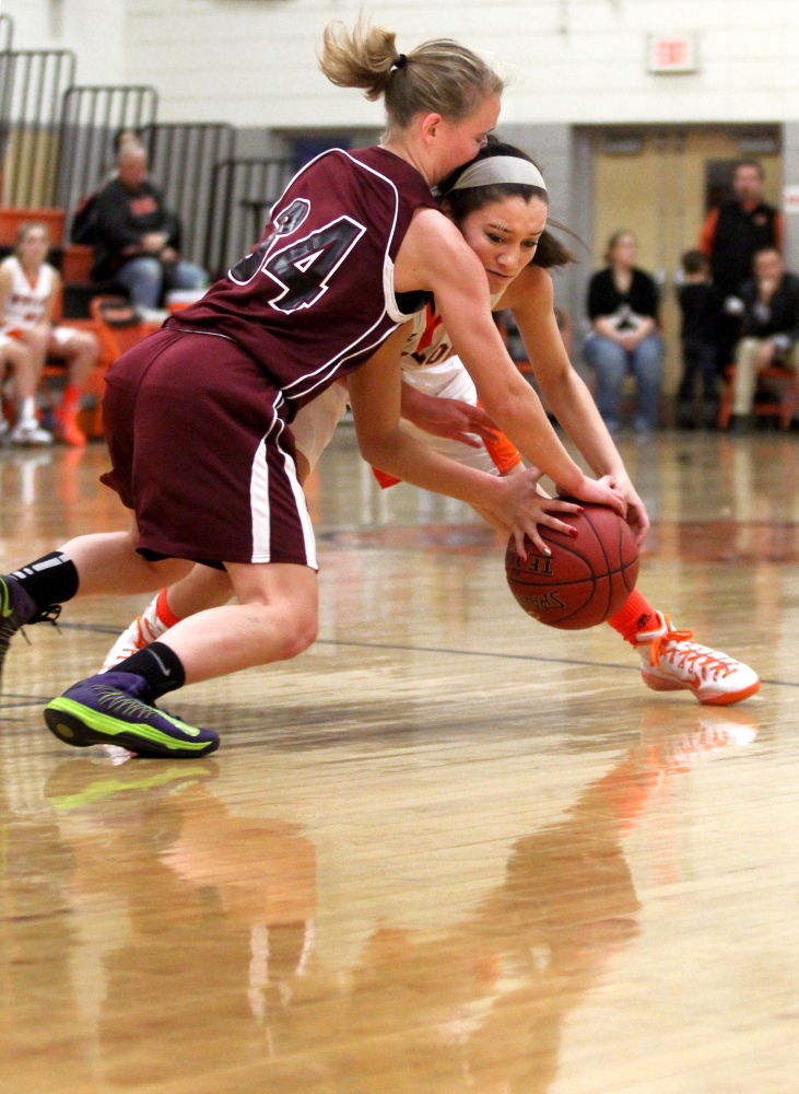 Maine Central Institute’s Sydney Morton, left, butts heads with Winslow High School’s Devin Fitzgibbons while battling for the ball during an Eastern B game Friday night.