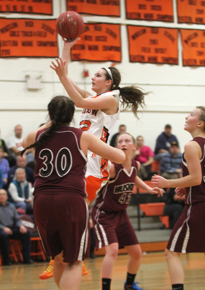 Winslow High School’s Delaney Wood drives past Katie Hughes (30) and several other Maine Central Institute defenders for a basket during an Eastern B game Friday night.