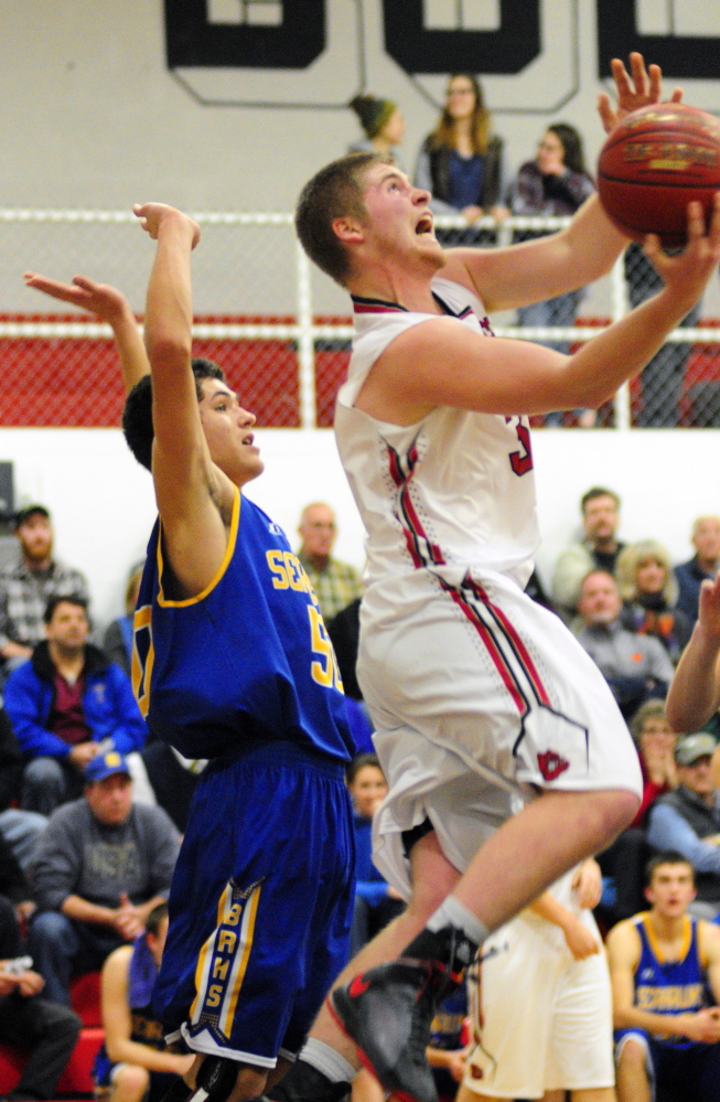 Boothbay’s Abel Bryer watches as Hall-Dale’s Brian Allen tries to put up a shot under the basket during a Western C game Friday in the Penny Gym at Hall-Dale High School.