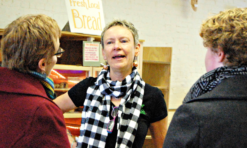 Waterville Mayor Karen Heck greets shoppers Saturday morning at Barrels Community Market on Main Street in Waterville.
