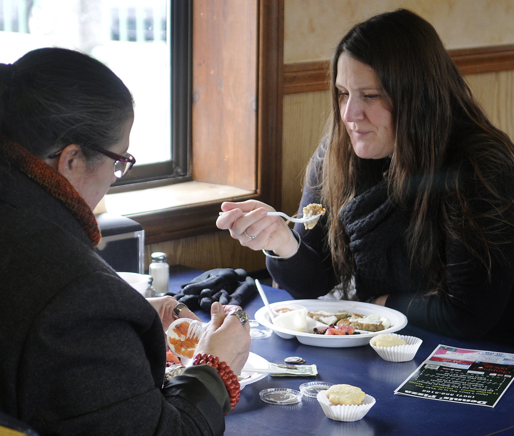 Dawn Thistle, right, and her mother, Marguerite Ridgway, eat latkes Sunday at Dennis’ Pizza, which hosted Gardiner’s annual latke party in observance of Hanukkah.