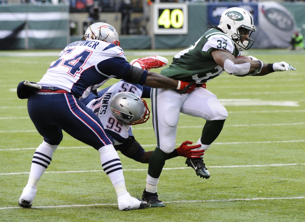New York Jets running back Chris Ivory (33) breaks a tackle by New England Patriots’ Chandler Jones (95) and Dont’a Hightower (54) during the first half Sunday in East Rutherford, N.J. The Patriots won 17-16.