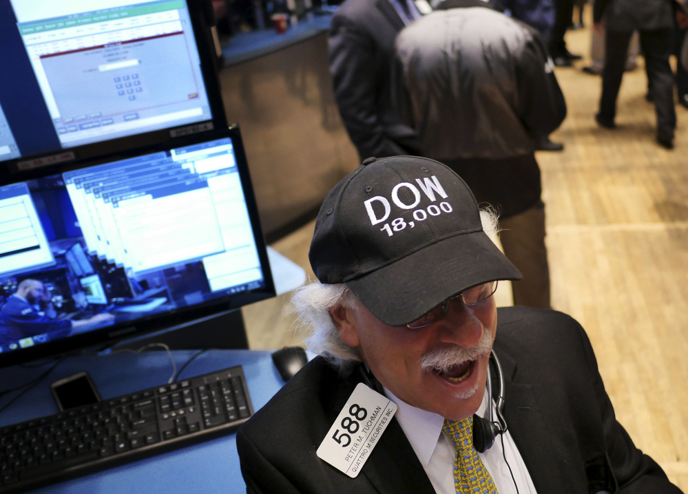 Peter Tuchman wears a “DOW 18,000” hat on the floor at the New York Stock Exchange in New York on Tuesday, when U.S. stocks pushed further into record territory.