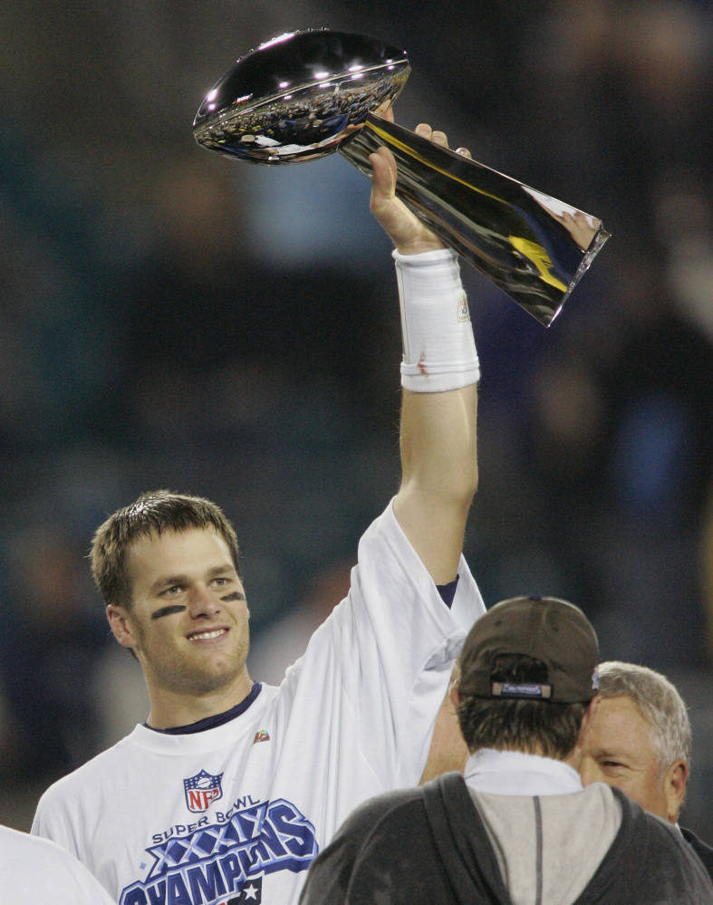 New England Patriots quarterback Tom Brady raises the Vince Lombardi Trophy over coach Bill Belichick and team owner Robert Kraft, right, after they beat the Philadelphia Eagles in  Super Bowl XXXIX. Brady and the Patriots are aiming for a fourth Super Bowl title. Tim Duncan and the San Antonio Spurs are defending the NBA championship for the fifth time. Different sports, but similar dynasties with solid ownership, demanding coaches and humble superstars.