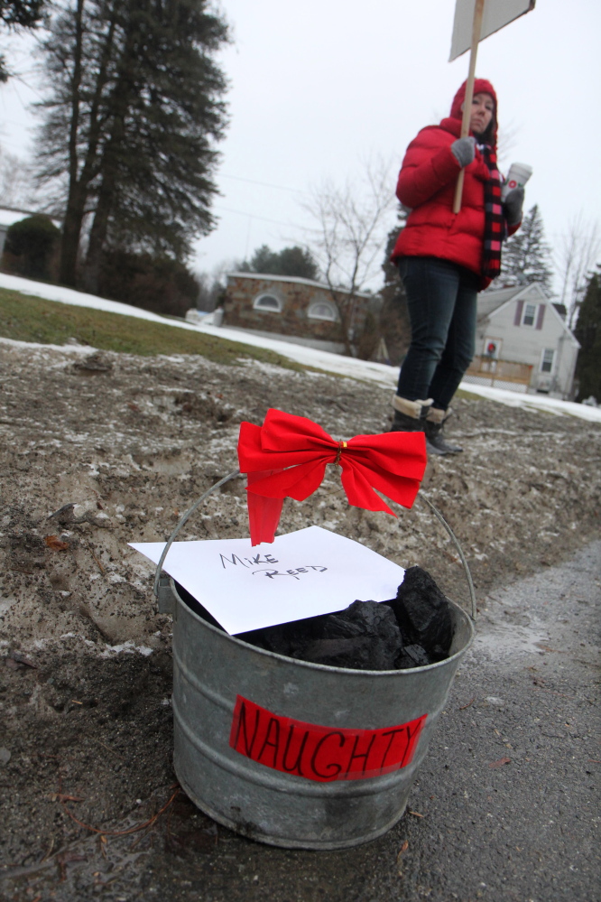 FairPoint workers put a bucket of coal on the sidewalk outside the Winslow home of Mike Reed, Maine president for Fairpoint, on Tuesday to symbolize their unhappiness with contract negotiations.