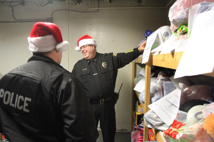 Fairfield Police Chief Thomas Gould pulls Christmas presents off the shelf Tuesday for his officers to deliver to local families.