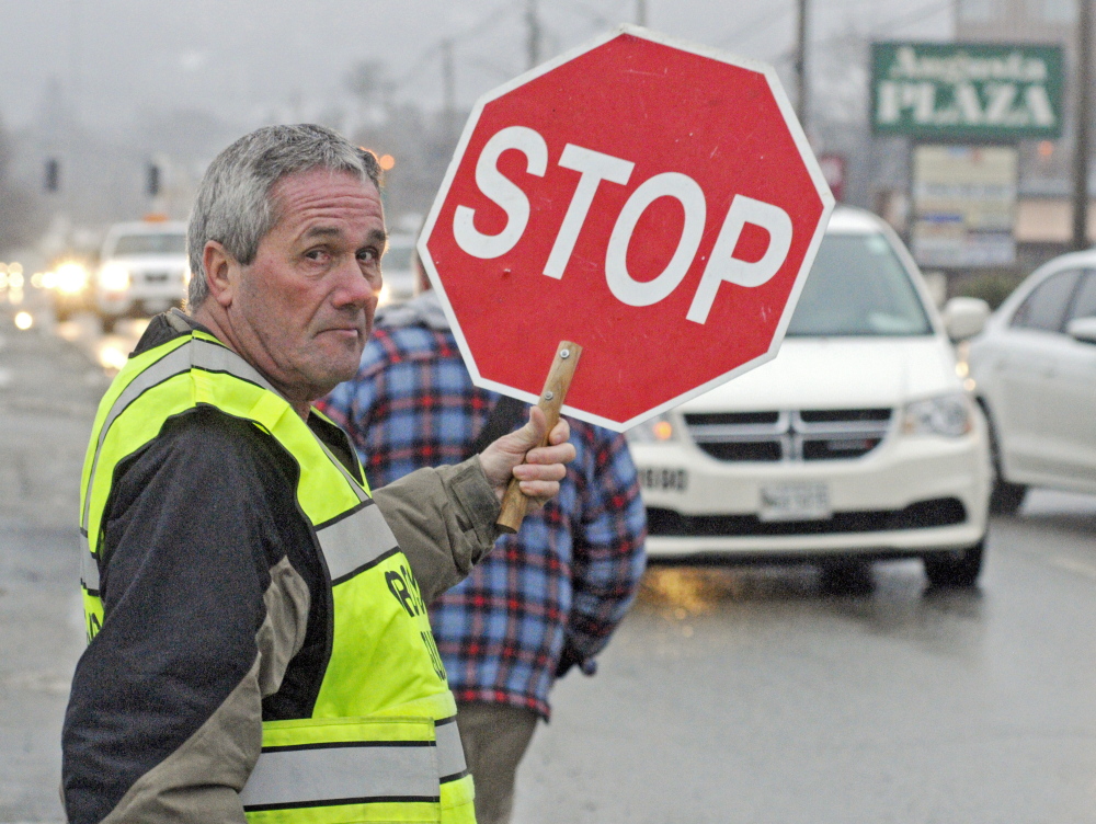 Crossing guard Reggie Gagne has been hired by Augusta schools to help children cross busy Western Avenue following public outcry that a school board subcommittee voted to eliminate all crossing guards across the city.
