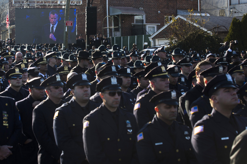 Police officers turn their backs as New York City Mayor Bill de Blasio speaks at the funeral of New York City police officer Rafael Ramos in the Glendale section of Queens, Saturday, Dec. 27, 2014, in New York. Ramos and his partner, officer Wenjian Liu, were killed Dec. 20 as they sat in their patrol car on a Brooklyn street. The shooter, Ismaaiyl Brinsley, later killed himself.