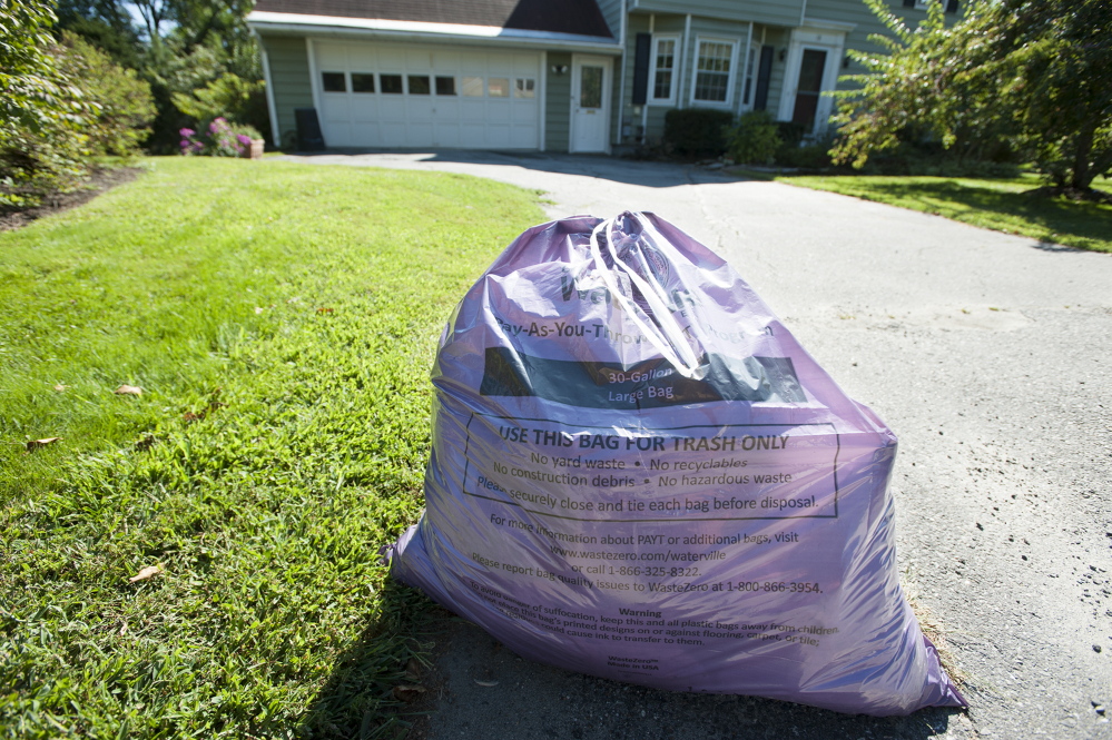A purple trash bag awaits pick up by disposal personnel along Johnson Heights in Waterville in September. The city’s pay-as-you-throw trash disposal system has been a success but has raised the rancor of some who see the purchase of bags as an additional tax.