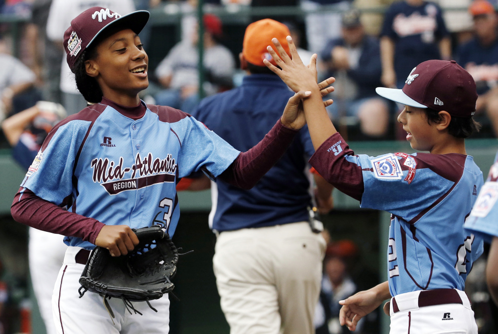 In this Aug. 15, 2014, file photo, Pennsylvania pitcher Mo’ne Davis, left, celebrates with teammate Jack Rice (2) after getting the final out of a 4-0 shutout against Tennessee during a baseball game in United States pool play at the Little League.