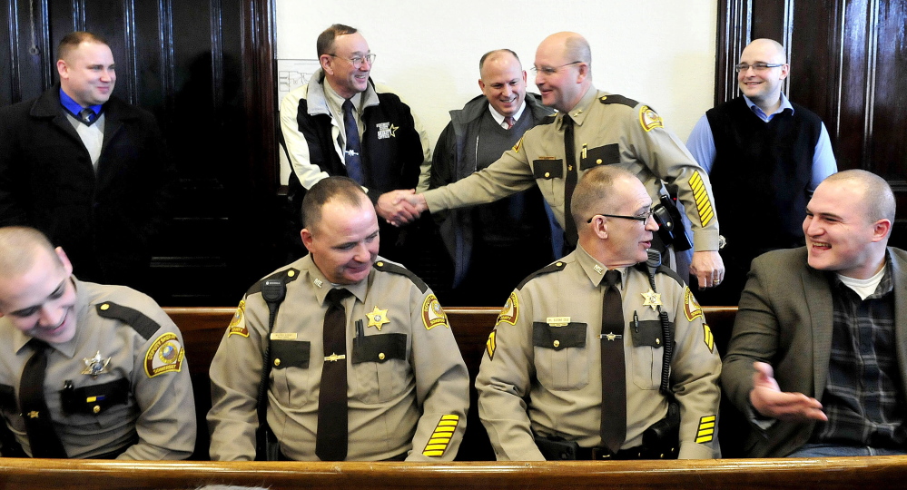 Dale Lancaster, right, shakes hands with retiring Penobscot County Sheriff Glenn Ross beside dozens of officers from several departments prior to a swearing-in ceremony as the new Somerset County Sheriff in Skowhegan on Monday.