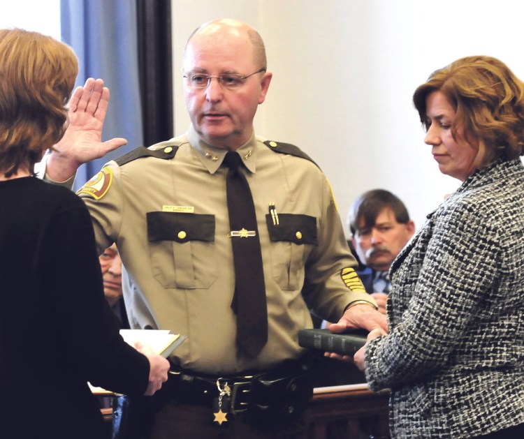 Dale Lancaster takes the oath of office as 30th Somerset County sheriff, as his wife Debbie holds a Bible during a ceremony at the Somerset Courthouse in Skowhegan on Monday. At left is executive secretary Karen Morrill, who administered the oath. Looking on is Jim Ross who moments later was sworn in as chief deputy.