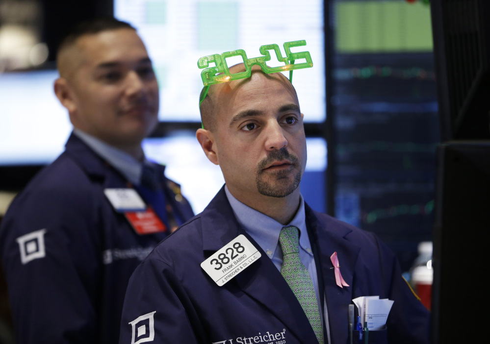 A trader wears glasses in the shape of 2015 while working on the floor at the New York Stock Exchange in New York on Wednesday.