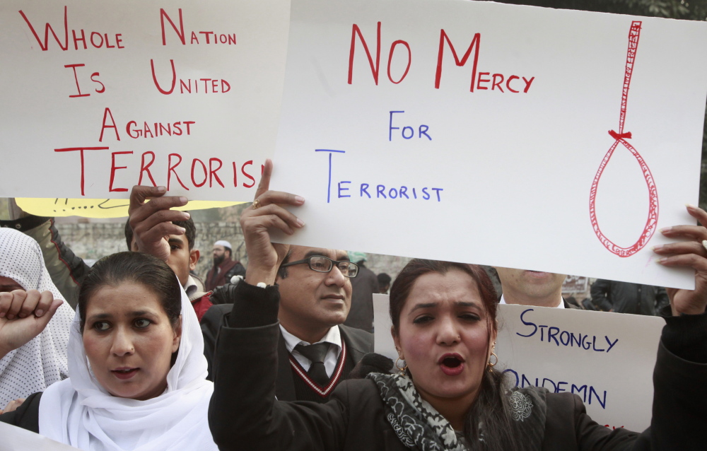 Civil society activists hold placards as they chant slogans condemning the attack on the Army Public School by Pakistan Taliban gunmen, during a rally in Lahore, Pakistan, on Thursday. The government and courts are moving toward executing convicted terrorists.  Reuters