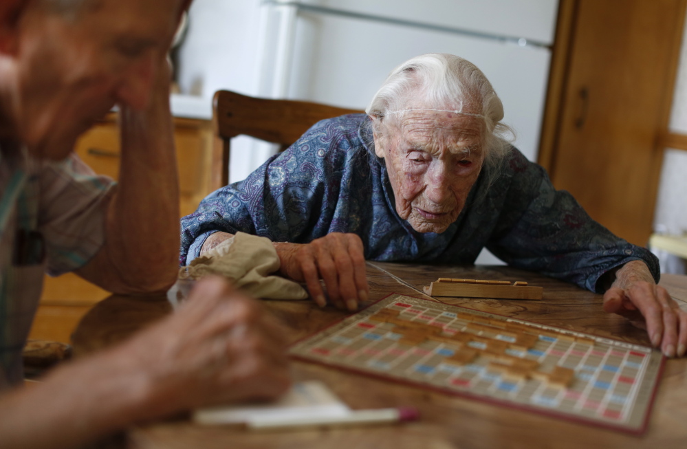 Anna Stoehr plays Scrabble at her home in Pottsdam, Minn., with her son, Harlan. Stoehr had recently joined Facebook, which sent her a bouquet of 114 flowers on her birthday. AP Photo/The Star Tribune, Richard Tsong-Taatarii