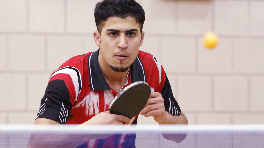 Fouad Abdullah, 20, is a big attraction at a Kennebec program because of his considerable table-tennis skills. Abdullah, who emigrated from a war-torn Iraq, arrived in Maine four months ago and won both the singles and doubles state table tennis championship in November. Photo by Gregory Rec/Staff Photographer