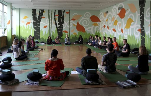 During a class in October, after a half-hour of yoga, students are asked to visualize a stressful moment in their lives and notice the negative internal dialogue in their heads. The Associated Press