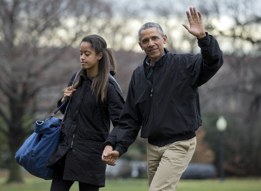 The Associated Press President Barack Obama with his daughter Malia Obama, waves as they arrive at the White House in Washington on Sunday from a family vacation in Hawaii.