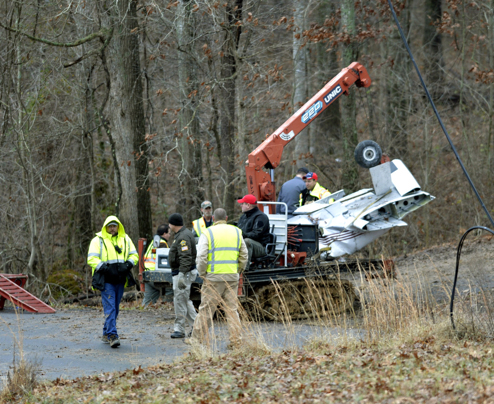 Salvage workers bring out part of a Piper PA-34’s fuselage, wing, and landing gear from a crash site Sunday in Kuttawa, Ky.