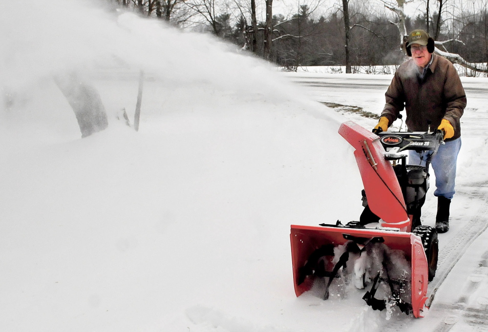 Ken Tozier uses his snowblower to clear off the three inches of snow from his driveway before freezing rain developed at his home in Unity on Sunday.