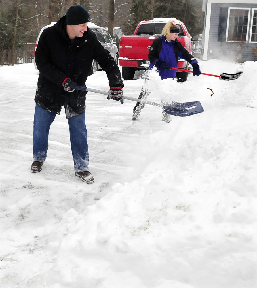 Working as a team, Peter and Lisa Hallen shovel snow at their home in Waterville on Sunday.