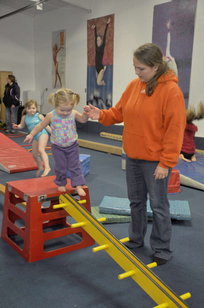 Mary Chase helps her 21-month-old daughter Emerson on a balance apparatus during an open house at Decal Gymnastics in Skowhegan Saturday. The Skowhegan Parks and Recreation gymnastics programs will now be held at the 19 Waterville Road facility.